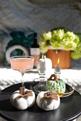 Cozy autumn composition, wicker basket with white pumpkins, candles and green gypsophila, autumn.