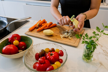 Woman Cooking Healthy Meatballs with Potatoes and Carrots in a Contemporary Kitchen Setting
