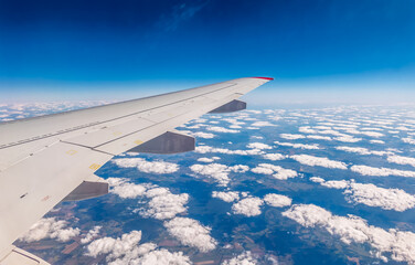 Obraz premium View from the airplane window at a beautiful cloudy sky and the airplane wing