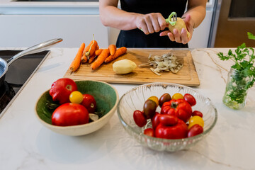 Woman Cooking Potatoes and Fresh Vegetables in a Contemporary Kitchen Setting