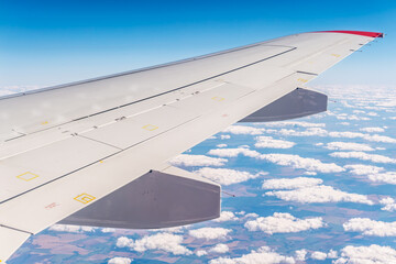 View from the airplane window at a beautiful cloudy sky and the airplane wing