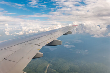 Obraz premium View from the airplane window at a beautiful cloudy sky and the airplane wing