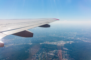 View from the airplane window at a beautiful cloudy sky and the airplane wing