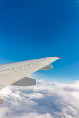 Obraz premium View from the airplane window at a beautiful cloudy sky and the airplane wing