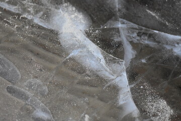 transparent ice on the river with sandy bottom