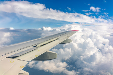 Obraz premium View from the airplane window at a beautiful cloudy sky and the airplane wing