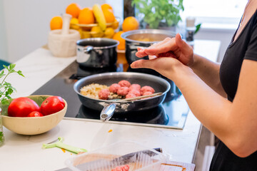 Woman Preparing Meatballs with Mashed Potato and Carrot in Modern Kitchen Setting