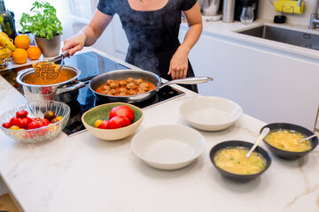 Woman Preparing Healthy Meatballs with Mashed Potatoes in a Contemporary Kitchen Setting