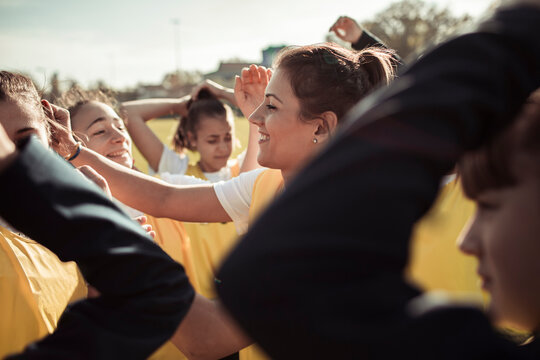 Teen soccer team huddling before match on outdoor field