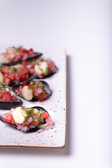 Peruvian appetizer called Choros a la chalaca on a tray on a white background