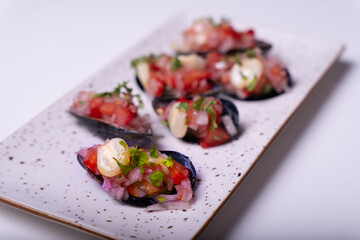 Close-up of appetizers called Choros a la chalaca on a white tray