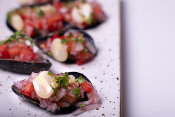 Close-up of appetizers called Choros a la chalaca on a white background