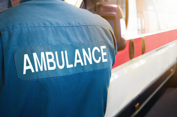 Ambulance and paramedic - emergency services worker and ambulance vehicle on standby. Medically equipped for patients and paramedics. Transport for health care facility or hospital, for treatment.
