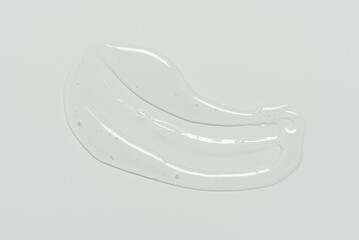 Transparent smear of cosmetic gel on gray background top view