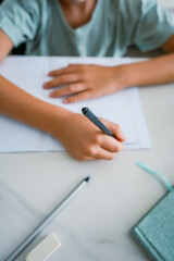 Close-up of child's hands writing 