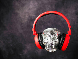 Party scull made of small mirrors wearing red colorful headphone. Abstract super DJ concept. Fan of...