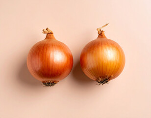 Two Golden Onions on Pale Peach Background