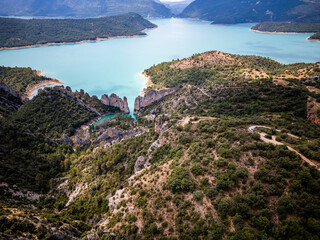 Aerial View of the Wall of Finestres – Limestone Cliffs Rising from Turquoise Reservoir in...