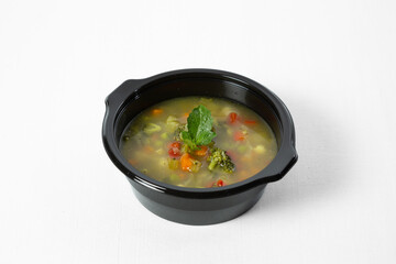 Vegetable soup in a bowl on a white background