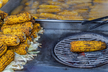 Popular Turkish street food, misir, freshly boiled sweet corn on the cob, roasted on a coal grill...