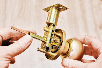Door knob with spherical design and locking mechanism being prepared for mounting, showcasing its...