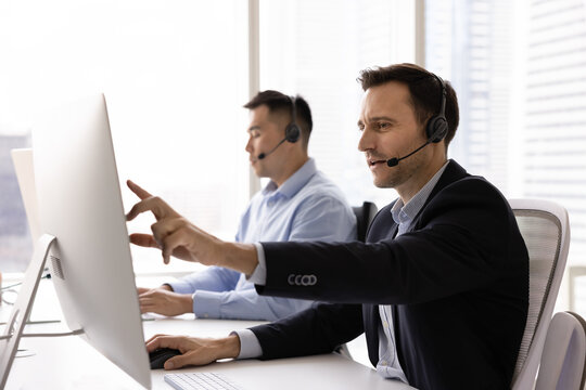 Hispanic man, call center employee answering inquiries and resolving customer issues, troubleshooting technical problems remotely, providing support over headset and videocall seated at desk in office