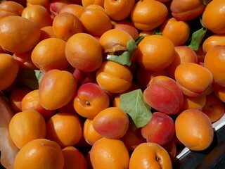 Fresh peaches displayed for sale in sunny outdoor farmers market
