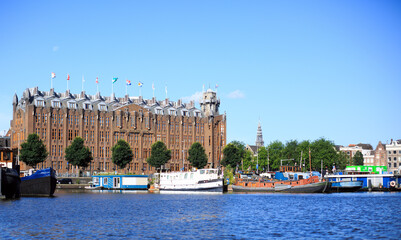 View of Amsterdam Harbour with small boats and old brick built building