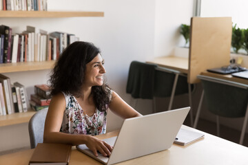Happy Indian businesswoman, freelancer working on business online project, doing research or...