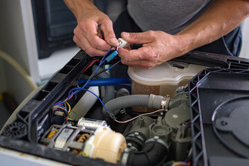The master repairs the dishwasher at home