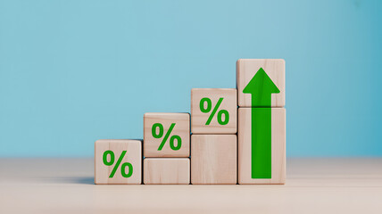 Wooden blocks with percentage symbols ascend in a stair-step pattern culminating in a vibrant green upward arrow signifying financial growth and success.