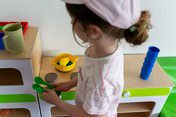 Preschooler Engaged in Imaginative Play with Toy Kitchen Set