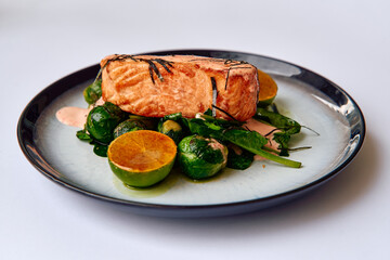 Grilled Salmon Fillet on a Bed of Fresh Spinach and Brussels Sprouts with a Touch of Lime and a Creamy Sauce, Perfect for a Healthy Meal Option