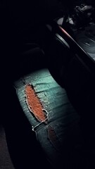 Torn chair with sunlight coming in illuminating the torn part of the chair.