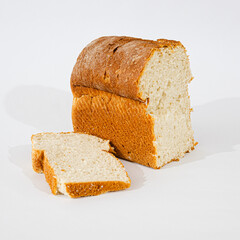 Pan artesanal recién horneado, con corteza dorada y miga esponjosa, presentado sobre fondo blanco. Ideal para representar comida casera, cocina tradicional y productos de panadería natural.