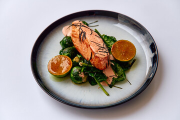 Deliciously Cooked Salmon Served with Fresh Spinach and Citrus Garnish for a Healthy and Flavorful Meal