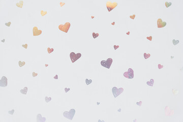 Multiple pastel iridescent heart shapes scattered and isolated on a plain white background. Suitable for romantic, love, or celebration themed designs and digital projects.
