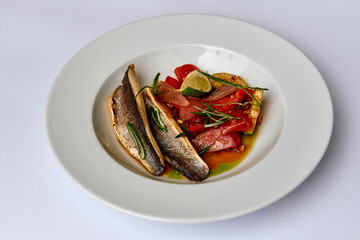 Deliciously Prepared Fish Dish Served with Fresh Vegetables and a Touch of Lime for a Flavorsome Dining Experience.