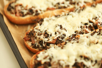 Hot baked toasts with melted cheese and mushrooms. Crispy bread with savory topping. Delicious...