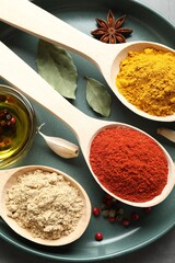 Many different spices in spoons on grey table, closeup