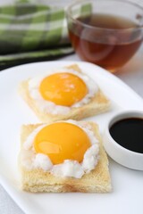 Tasty kaya toasts with half-boiled eggs served on table, closeup. Traditional asian breakfast