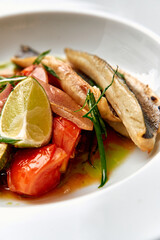 Deliciously Poised Dish Featuring Seared Fish Accompanied by Fresh Vegetables and a Zesty Lime...