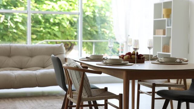 Beautiful table setting, chairs and decor in dining room. Camera moving right