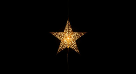 Obraz premium A Single Illuminated Star Shaped Lantern Hanging Against a Dark Background Casting a Warm and Inviting Glow Creating a Sense of Wonder and Serenity