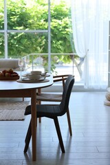 Beautiful table setting, chairs and decor in dining room. Interior design