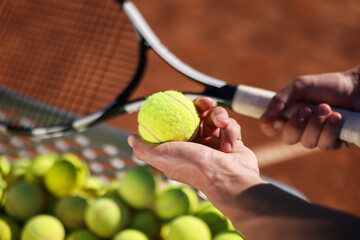 Man taking tennis ball out of cart at court, closeup