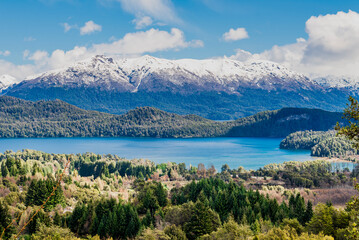 Naklejka premium The Bonito River Waterfall, surrounded by forests and mountains, is a tourist attraction in Villa La Angostura, Argentina.