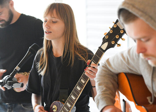 a group of young people sing and play guitar and drums - Powered by Adobe