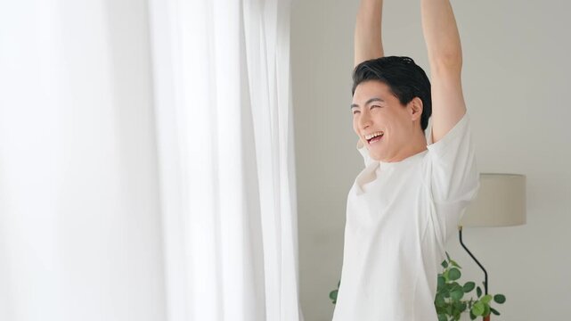 窓際で爽やかにストレッチする男性