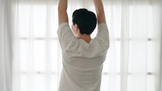 A man stretching by the window